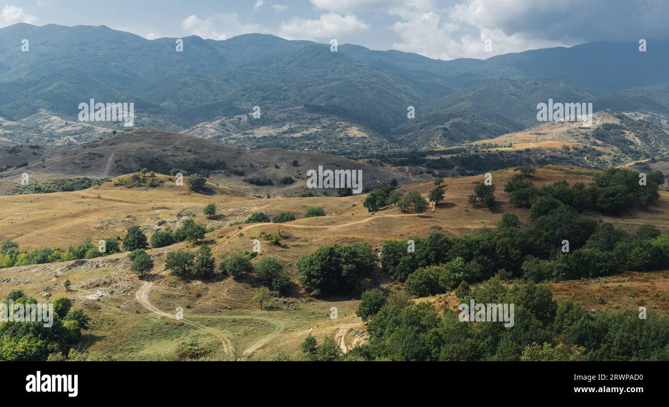 Sonniges Mittagslandschaftsfoto von wunderschönen Wiesen und großen Bergen im Hintergrund. Stockfoto