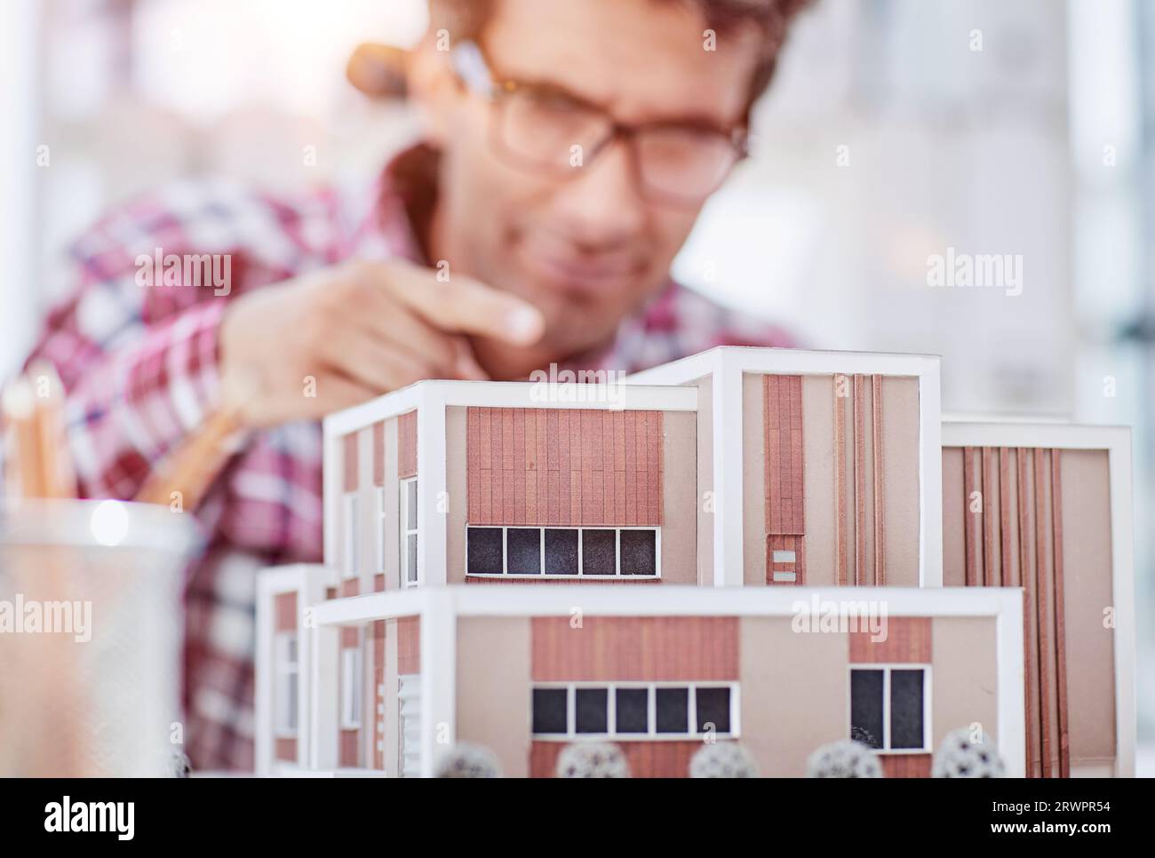 Junge Unternehmer oder Architekten mit Modell eines Hauses steht im Büro, arbeiten. Stockfoto