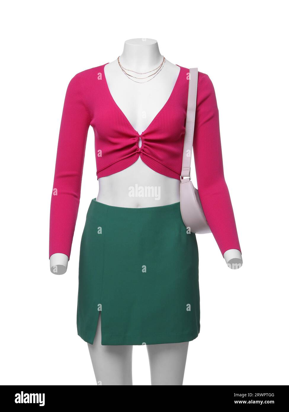 Weibliche Puppe mit grünem Rock und pinkfarbenem Oberteil mit Accessoires isoliert auf Weiß. Stylisches Outfit Stockfoto