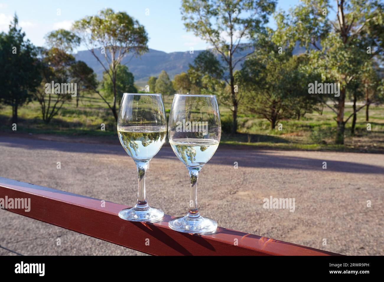 Zwei Weingläser mit Weißwein im wilpena Pfund Resort mit wilpena Pfund im Hintergrund. Der Nationalpark Ikara flinders Ranges in südaustralien Stockfoto