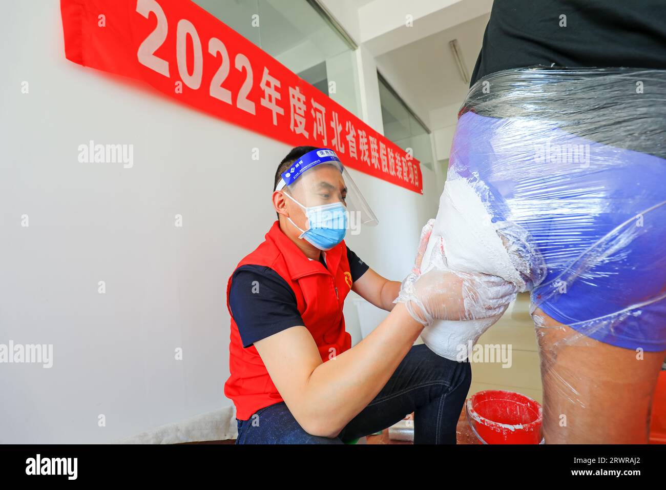 LUANNAN COUNTY, China - 13. Mai 2022: Mitarbeiter, die künstliche Gliedmaßen für Behinderte installieren, Nordchina Stockfoto