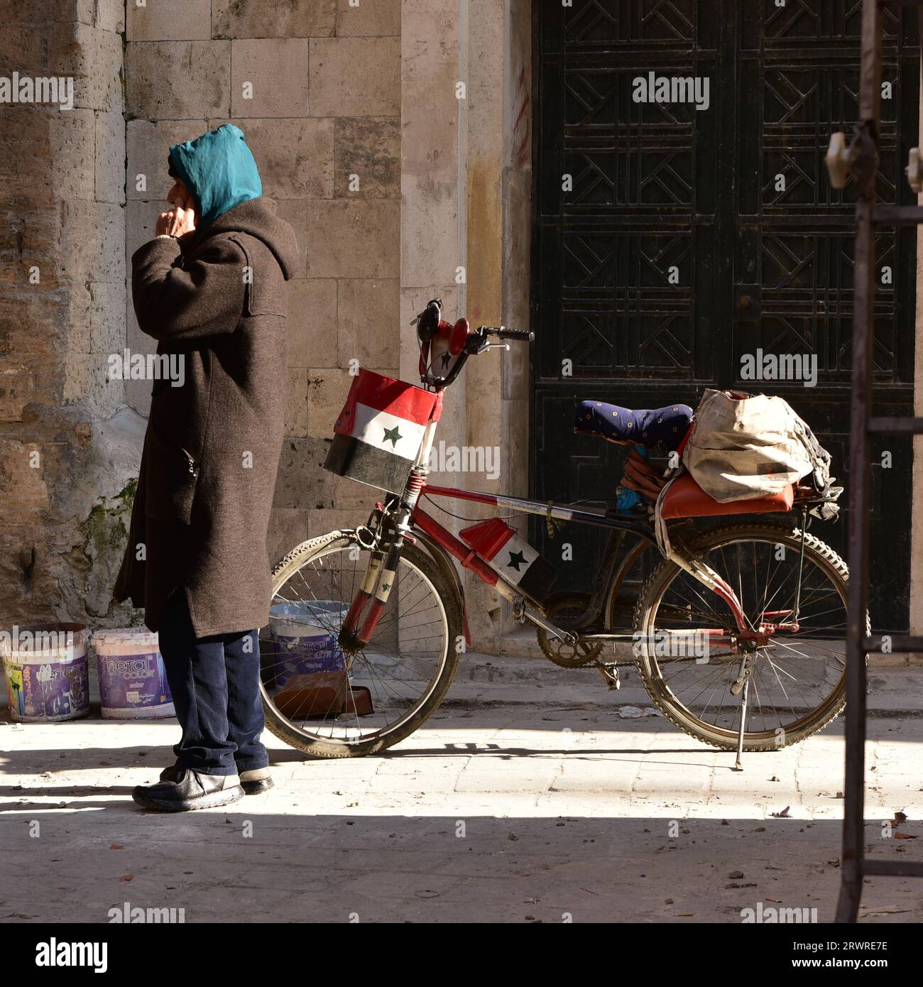 Ein wahrer syrischer Patriot, der in Hama, Syrien, eine modderscheinende Farwa trägt, die Nationalflagge auf seinem Fahrrad gemalt Stockfoto