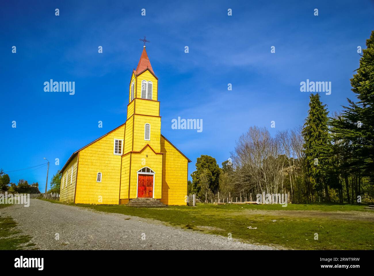 Foto von gelber Holzkirche umgeben von Grün in Chile Stockfoto