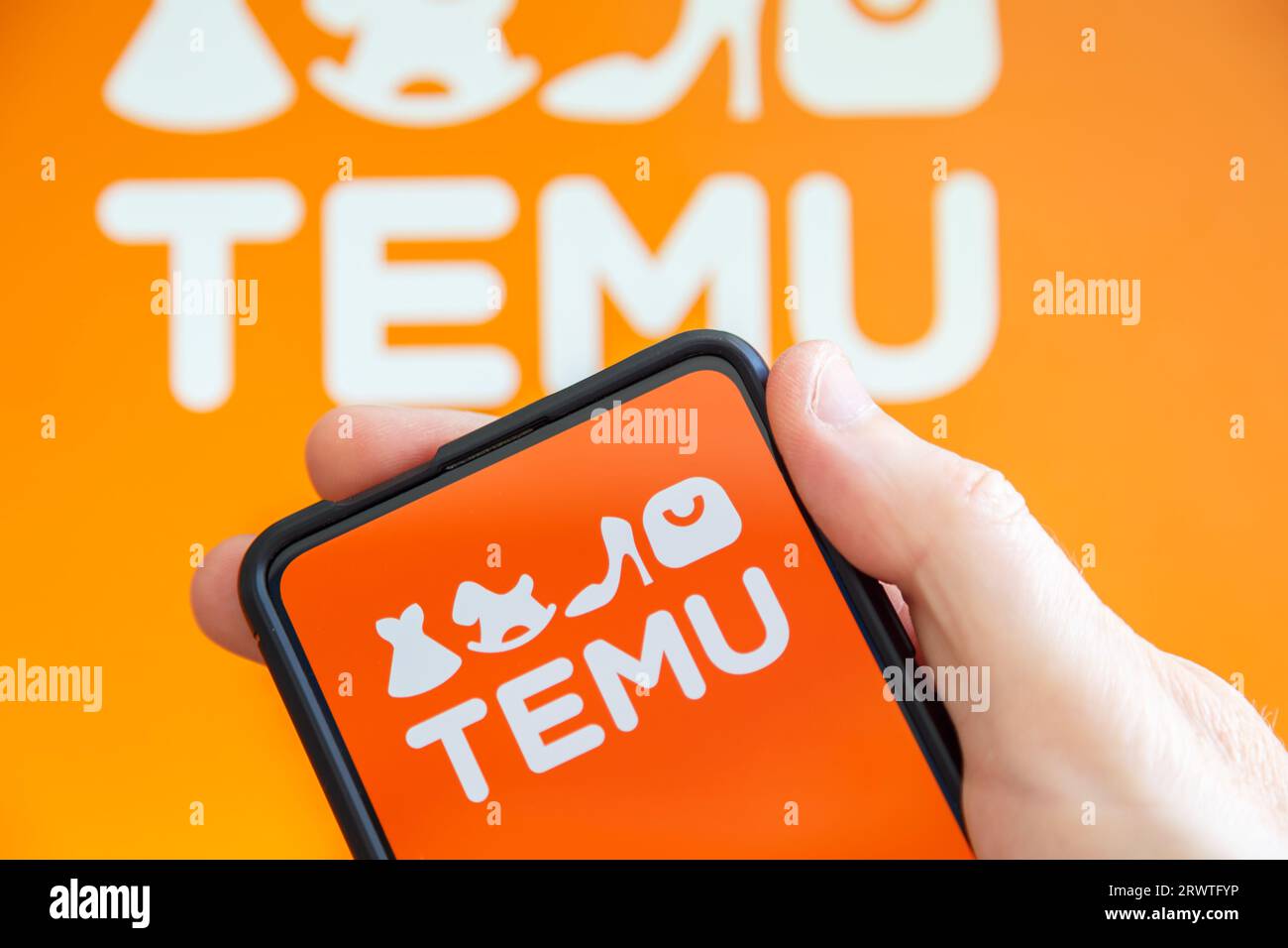 Stuttgart, Deutschland - 19. Juli 2023: Hand hält ein Mobiltelefon mit Temu-Logo Online-Marktplatz E-Commerce-Computer-Bildschirm in Stuttgart, Deutschland. Stockfoto