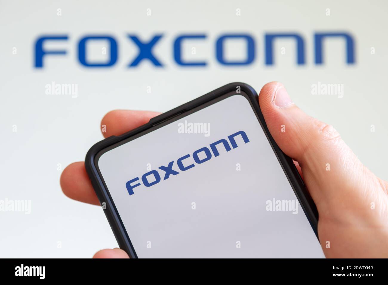 Stuttgart, Deutschland - 20. Juli 2023: Hand hält ein Mobiltelefon mit Foxconn-Logo auf dem Bildschirm des Computerherstellers in Stuttgart. Stockfoto