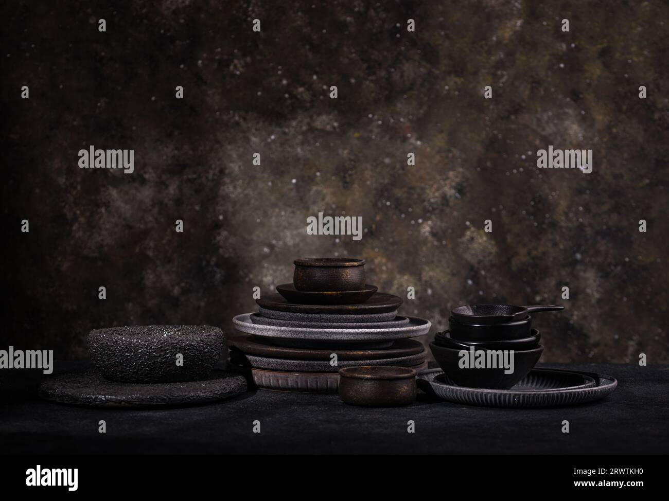 Set aus verschiedenen Craft-Tellern und Schüsseln auf dunklem Hintergrund Stockfoto
