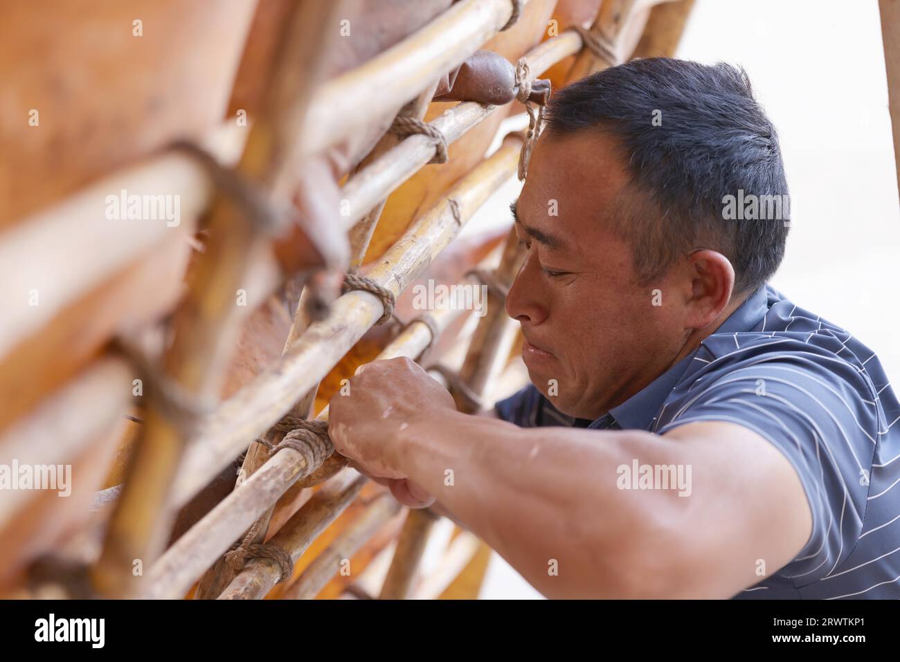 (230921) -- LANZHOU, 21. September 2023 (Xinhua) -- Niu Qiang repariert ein Lammfellfloß in Lanzhou, nordwestchinesische Provinz Gansu, 5. September 2023. Niu Qiang, ein Floßarbeiter aus Huining in der nordwestchinesischen Provinz Gansu, erledigt die Arbeit seit 27 Jahren, seit 16 Jahren, auf dem Lanzhou-Abschnitt des Gelben Flusses. Seit 2.000 Jahren werden Schaffellflöße für den Transport von Gütern auf dem Yellow River verwendet. Mit der Entwicklung der Wirtschaft und des Transportwesens nimmt die Anzahl der Flöße mit der Zeit allmählich ab, und die Transportform hat sich heute zu einer Touristenattraktion auf dem Yello entwickelt Stockfoto