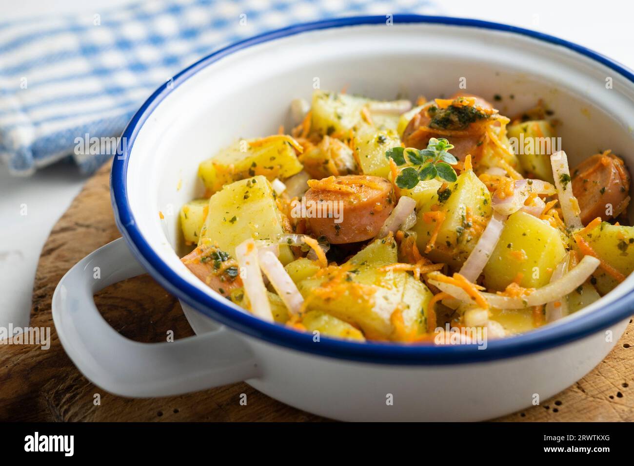 Wurstsalat mit Kartoffeln, Zwiebeln und grünem Pesto. Stockfoto