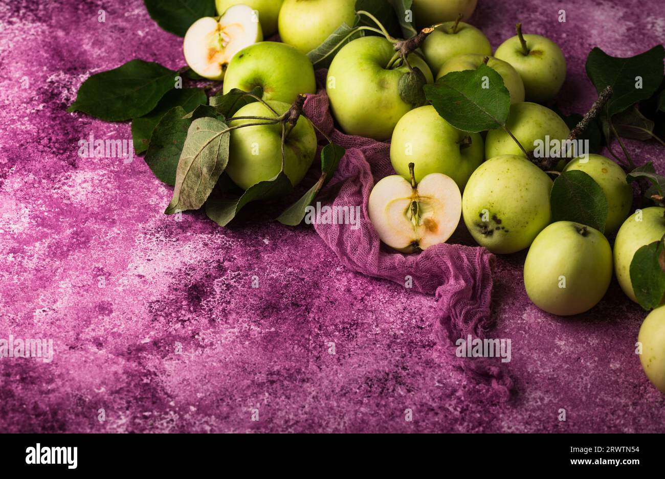 Frischer, reifer grüner Apfel auf violettem Hintergrund. Stockfoto