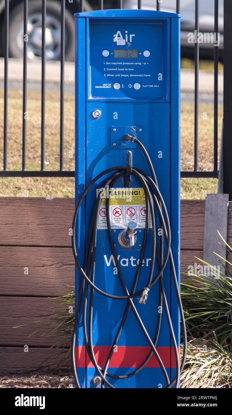 Kostenlose Selbstbedienungsluft und Wasser an der Tankstelle für Autofahrer in Queensland, Australien. Blauer Turm mit unordentlichen Spiralschläuchen. Stockfoto