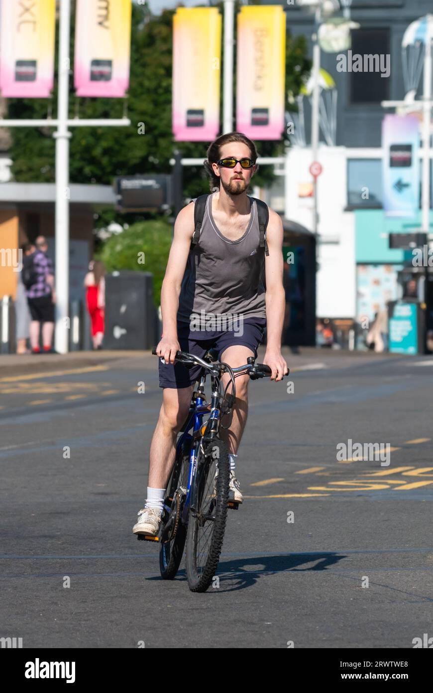 Junger Mann, der ohne Helm auf dem Fahrrad fährt. Männlicher Radfahrer, der auf einer Straße in Großbritannien fährt, ohne einen Fahrradhelm zu tragen. Stockfoto