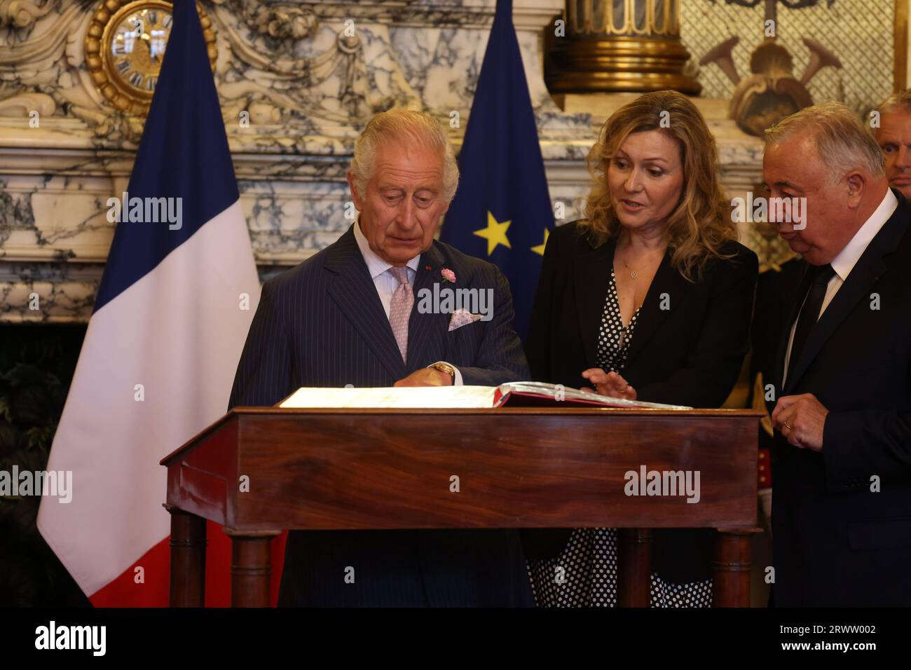 König Karl III., beobachtet vom Senatspräsidenten Gerard Larcher, und die Präsidentin der Nationalversammlung, Frau Yael Braun-Pivet, unterzeichnete das Besucherbuch in der Salle des Conference, als er am zweiten Tag des Staatsbesuchs in Frankreich vor den Senatsmitgliedern im luxemburgischen Palast in Paris ankommt. Es ist das erste Mal, dass ein Mitglied der britischen Königsfamilie aus der Senatskammer sprach. Bilddatum: Donnerstag, 21. September 2023. Stockfoto