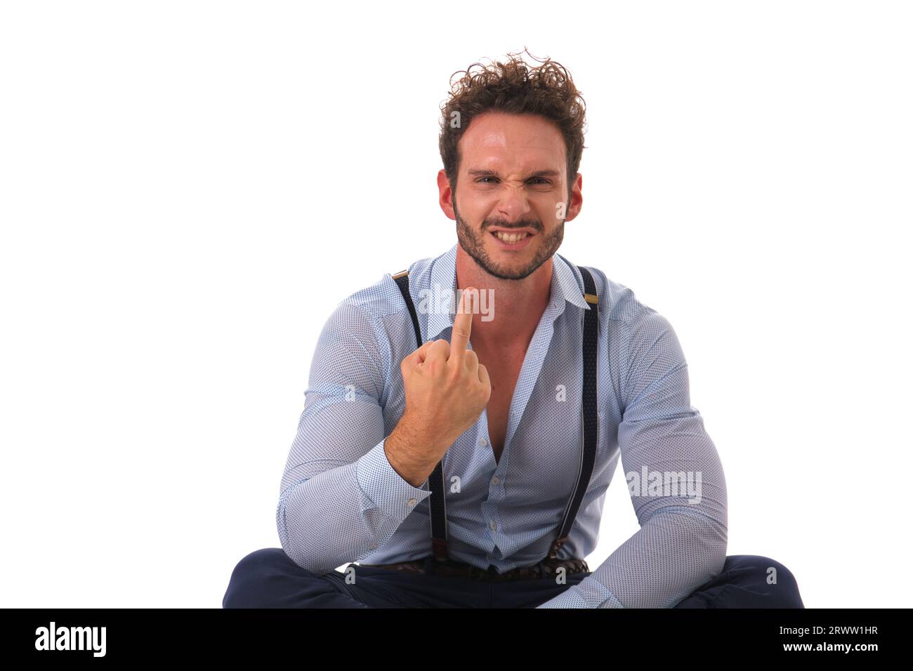 Ein erwachsener Mann mit Bart gibt ein unhöfliches Handzeichen und lächelt. Weißer Hintergrund, Studioeinstellung. Stockfoto