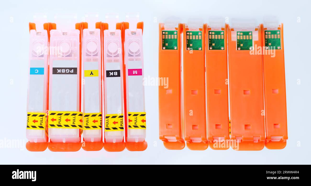 Satz nachfüllbarer Tintenbehälter isoliert auf grau. Preisgünstige Drucklösung. Stockfoto