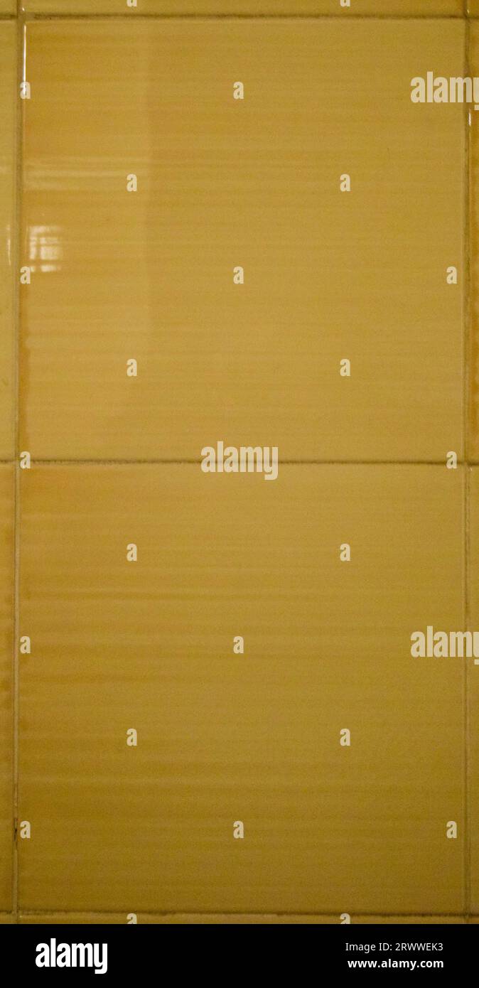 Gelbe Fliesen in einem alten Badezimmer Stockfoto