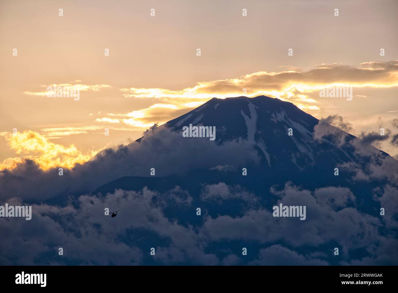 Fuji bei Sonnenuntergang mit Wolken und einem Kampfhubschrauber Stockfoto