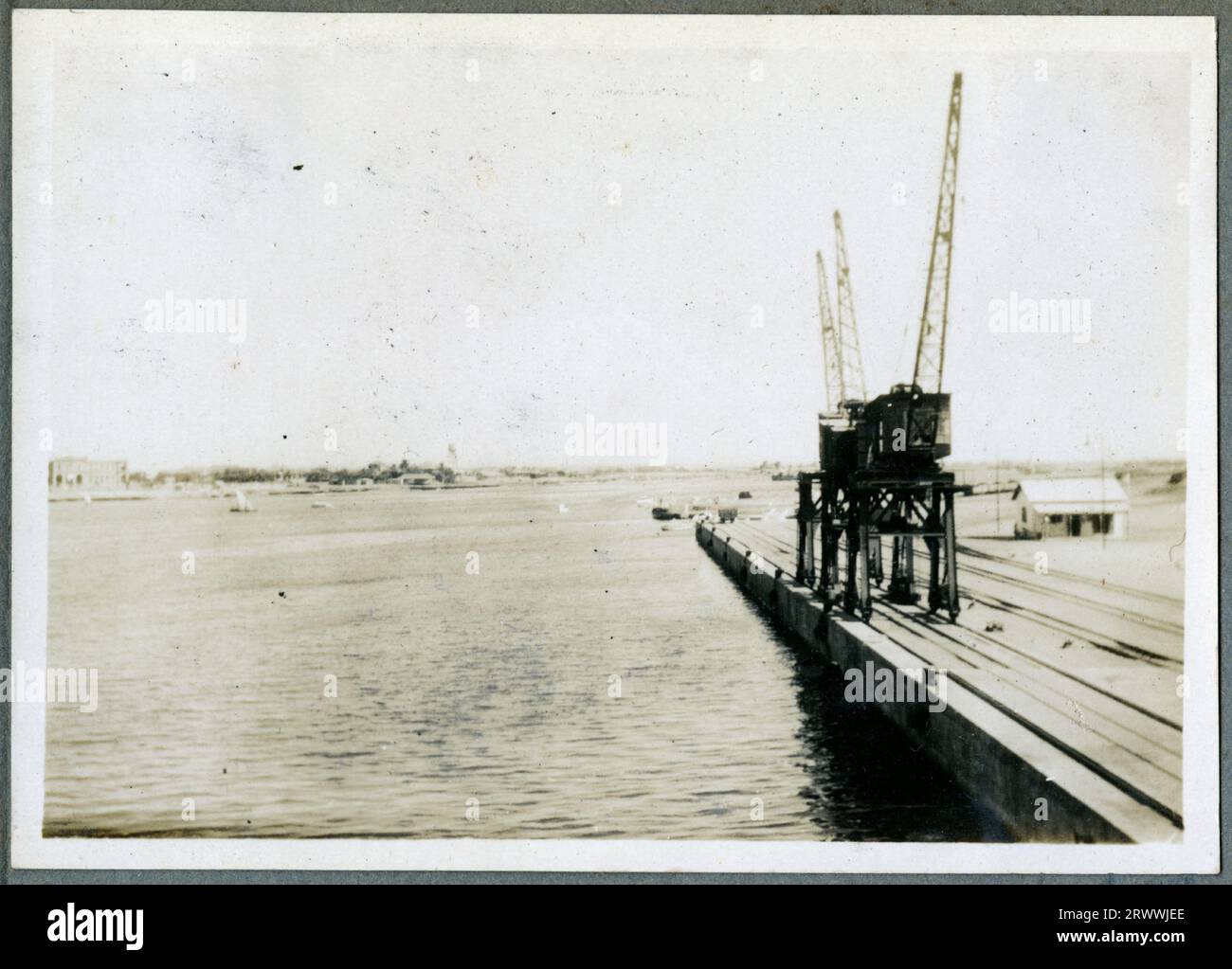 Eines von drei Fotos mit dem Titel „Investing Port Sudan 1932“. Dieses Bild zeigt ein kleines Boot auf See mit dem Land dahinter. Originalhandschrift: Enting Port Sudan 1932. Stockfoto