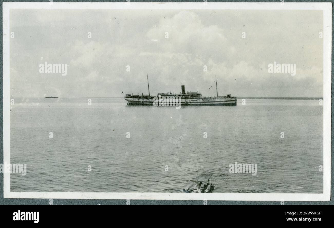 Das Krankenhausschiff HMHS Dongola, von der anderen Seite des Wassers aus gesehen. Die Küste ist hinter dem Boot zu sehen und es gibt ein kleines Boot im Vordergrund. Originalhandschrift: HMHS Dongola Sansibar 1917. Stockfoto