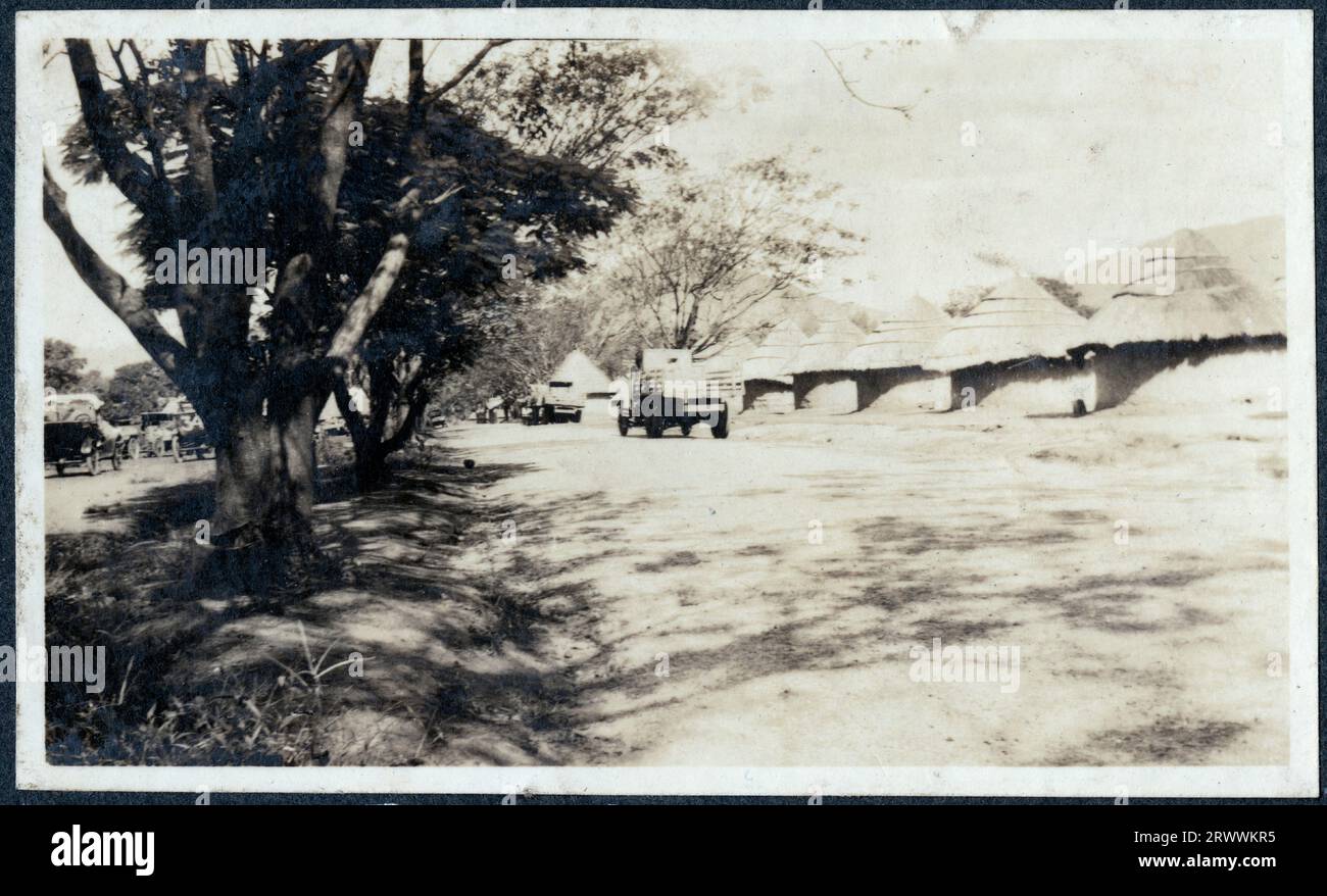 Ansicht eines Militärlagers mit einer Linie von Strohhütten mit einer Reihe von Militärfahrzeugen, die in der Nähe geparkt sind. Originalhandschrift: „M.T. [Mechanical Transport] Camp at Zomba“ C.A. [Central Africa]. Stockfoto
