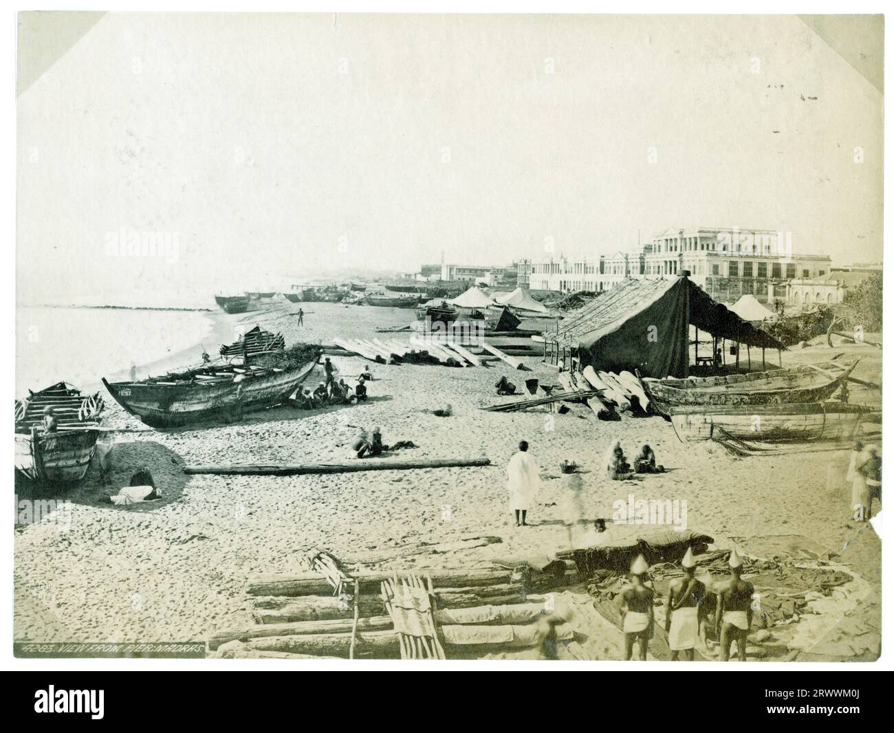 Blick auf Boote und indische Arbeiter am Strand von Madras. Es gibt ein großes Zelt am Strand und weiße Zelte in der Entfernung. Auf negativ eingeschrieben: 4283. Blick vom Pier; Madras. Die Überschrift lautet: Madras. Stockfoto