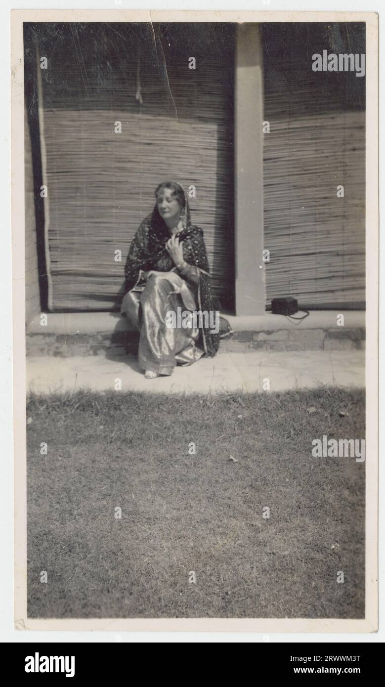 Frau in Sari sitzt auf einer Stufe. Die Bildunterschrift lautet: Englische Dame in indianischer Kleidung. Kaschmir, 1934 (oder Rawlpindi?). Stockfoto