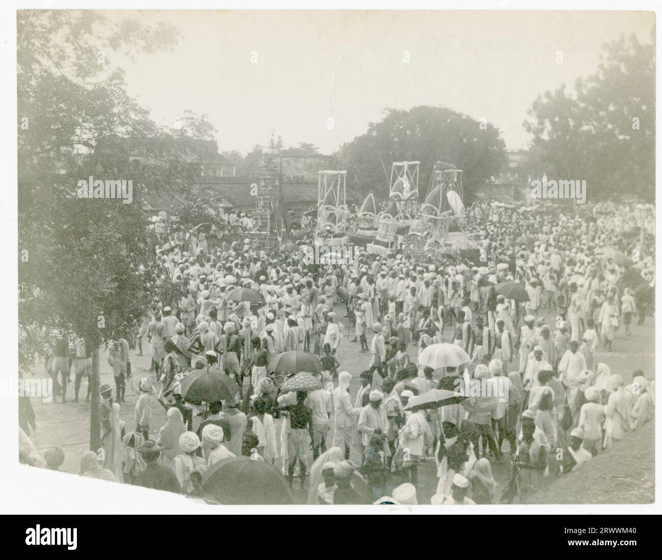 Religiöse Prozession mit Pferdekutschen inmitten einer großen Festversammlung von traditionell gekleideten Indianern. Bäume säumen den Platz und Gebäude sind im Hintergrund zu sehen. Stockfoto