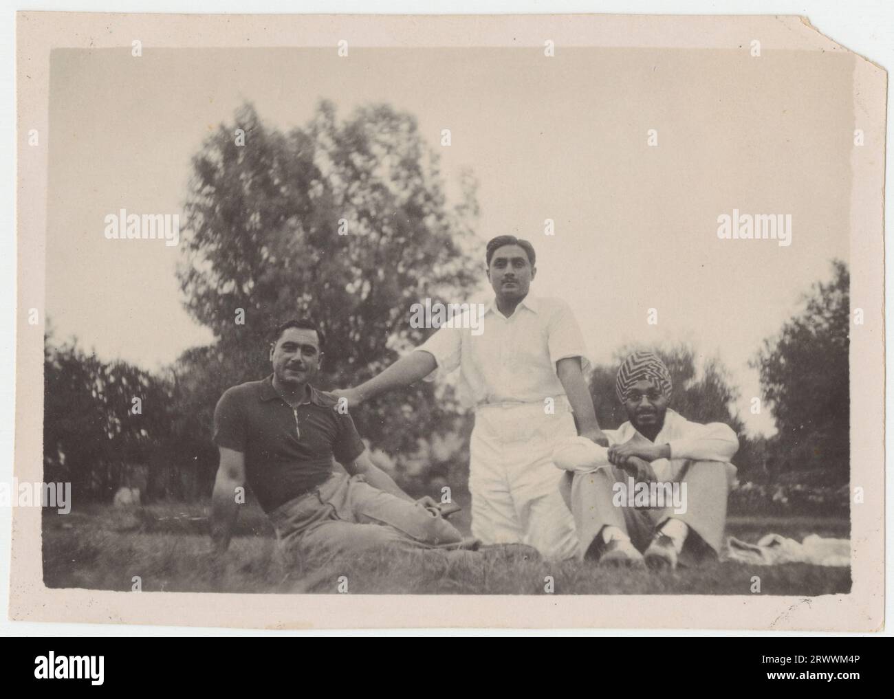 Drei junge Männer, die sich auf dem Rasen ausruhen. 32: Salim Khan mit Capt Nawabzada m Imbrahim Khan von Palinpur (L) und dem Yuvraj Bahatpur Pratap Singh von Nabha. Lahore, um 1933 - 34 separate Notizen vom Spender fügen hinzu: „Mein Großvater Salim Khan, mit einem Nawabzada des Palanpur-Staates und einem der Princelings des Nabha-Staates, Lahore um 1933 - 34 (wahrscheinlich der Gymkhana Cricket Ground). Stockfoto