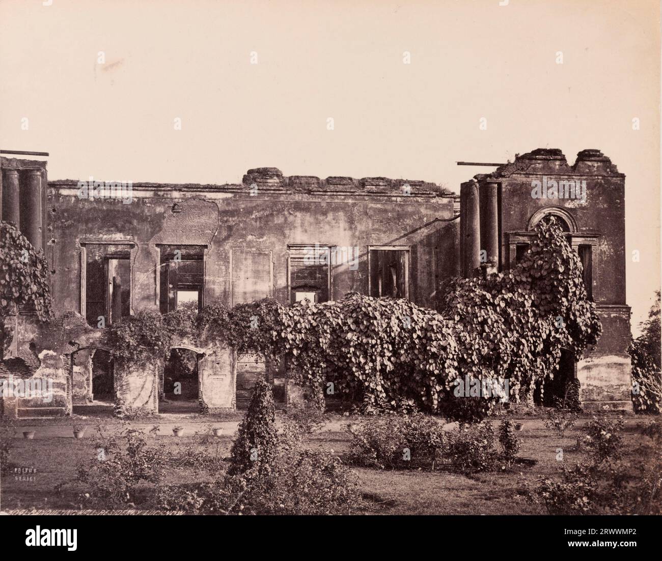 Aus nächster Nähe sehen Sie die Ruinen der mit Pflanzen bewachsenen British Residency Banqueting Hall. Sie wurde während der indischen Rebellion von 1857 ruiniert. Topf-Pflanzen säumen den Weg und Rasen vor dem Gebäude. Auf negativ eingeschrieben: Frith's Series. 3041 Bankettsaal, Residency, Lucknow. Die Bildunterschrift lautet: Lucknow Residency, Bankettsaal. Stockfoto