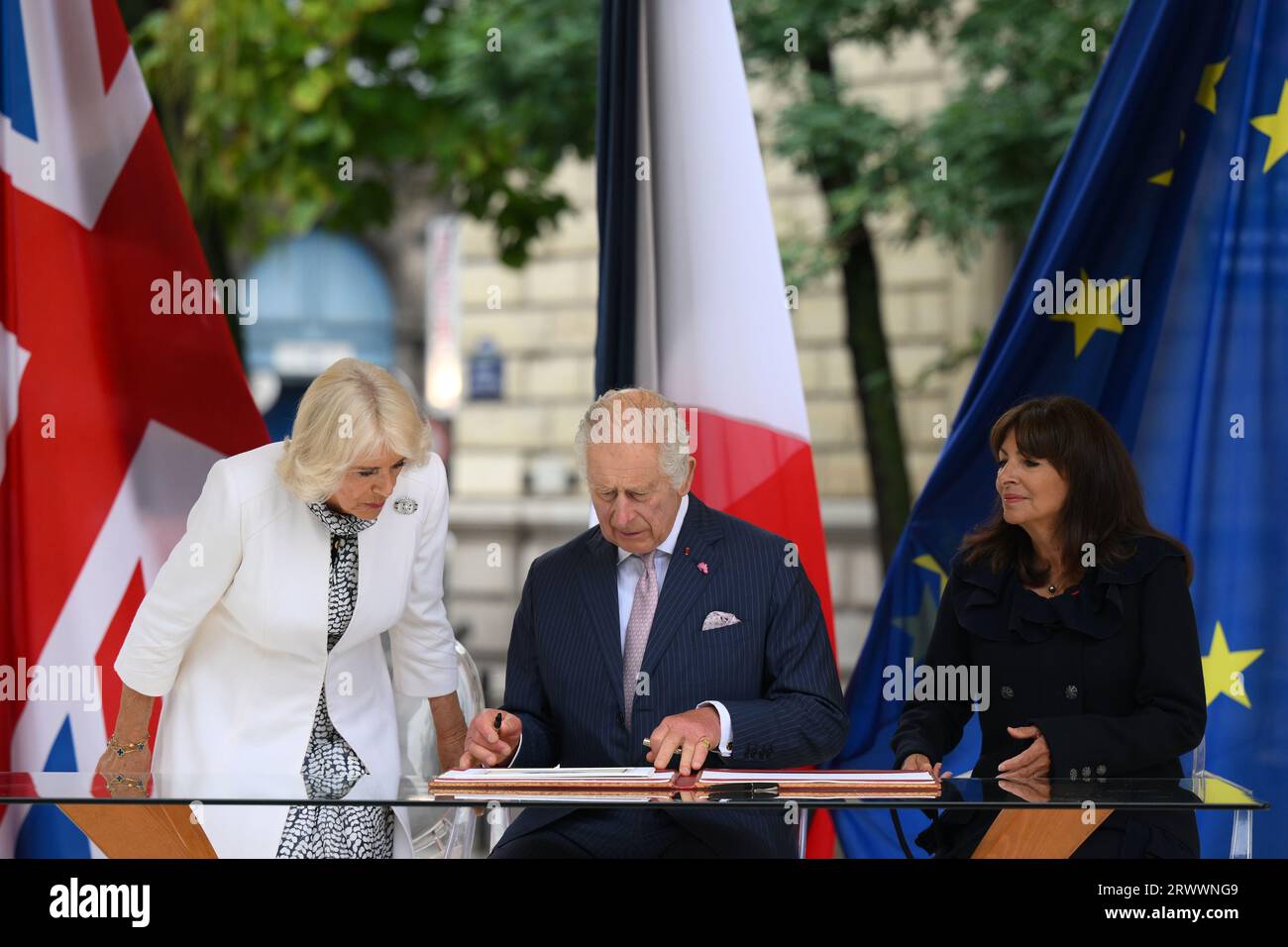 König Karl III. Und Königin Camilla mit der Pariser Bürgermeisterin Anne Hidalgo (rechts) unterzeichnen ein Buch nach dem Besuch des Pariser Blumenmarktes im Zentrum am zweiten Tag des Staatsbesuchs in Frankreich. Bilddatum: Donnerstag, 21. September 2023. Stockfoto