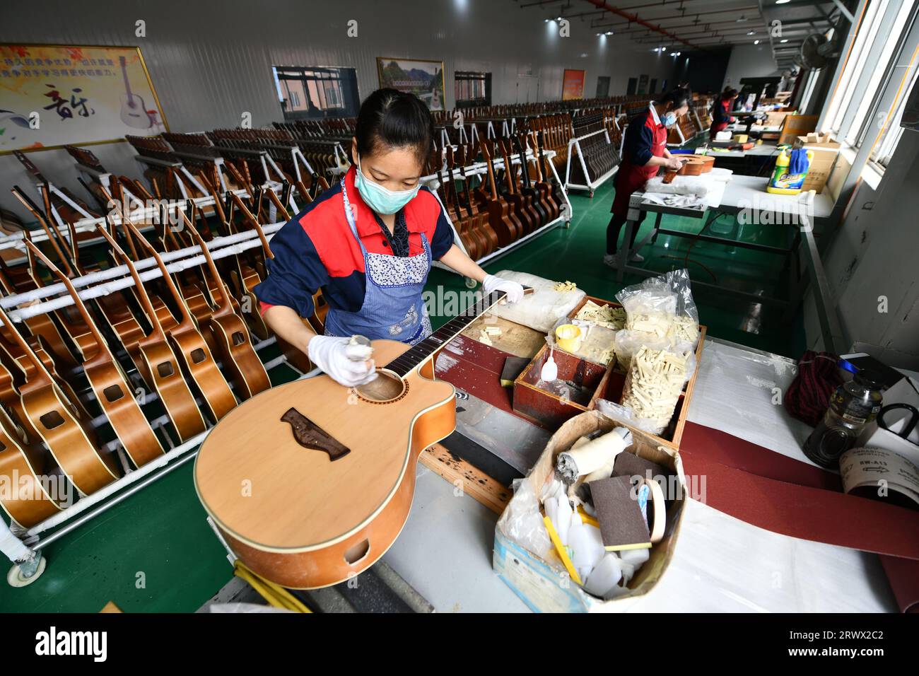 (230921) -- GUIYANG, 21. September 2023 (Xinhua) -- ein Mitarbeiter arbeitet an einer Gitarre in einer Werkstatt des Zheng'an Guitar Culture Industry Park im Kreis Zheng'an, Provinz Guizhou im Südwesten Chinas, 25. März 2020. Nach mehr als 200 aufwändigen und langwierigen Herstellungsverfahren kommen exquisit gefertigte Gitarren als charakteristische Produkte des Zheng'an County in der südwestlichen chinesischen Provinz Guizhou heraus. Diese Kunstwerke werden dann über die China-Europa-Güterzüge, den Wassertransport und andere Mittel in die Welt verteilt. UM MIT "Economic Watch: Chinesische Gitarrenindustrie reitet auf Wave o Stockfoto