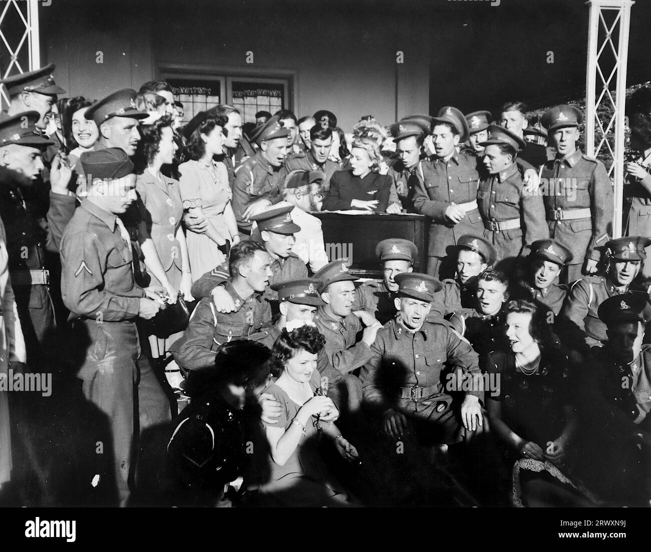 Mary Pickford unterhält die Truppen, bevor sie in ihrem Hollywood-Haus Tee serviert. Seltenes Foto: Aus einer Sammlung eines unbekannten britischen Soldaten über die No. 1 Composite Demonstration, AA Battery, Tour durch die USA, vom 11. Juli 1943. Dies ist eines von mehr als hundert Bildern in der Sammlung, die im Durchschnitt etwa 4 x 3 Zoll groß waren. Stockfoto