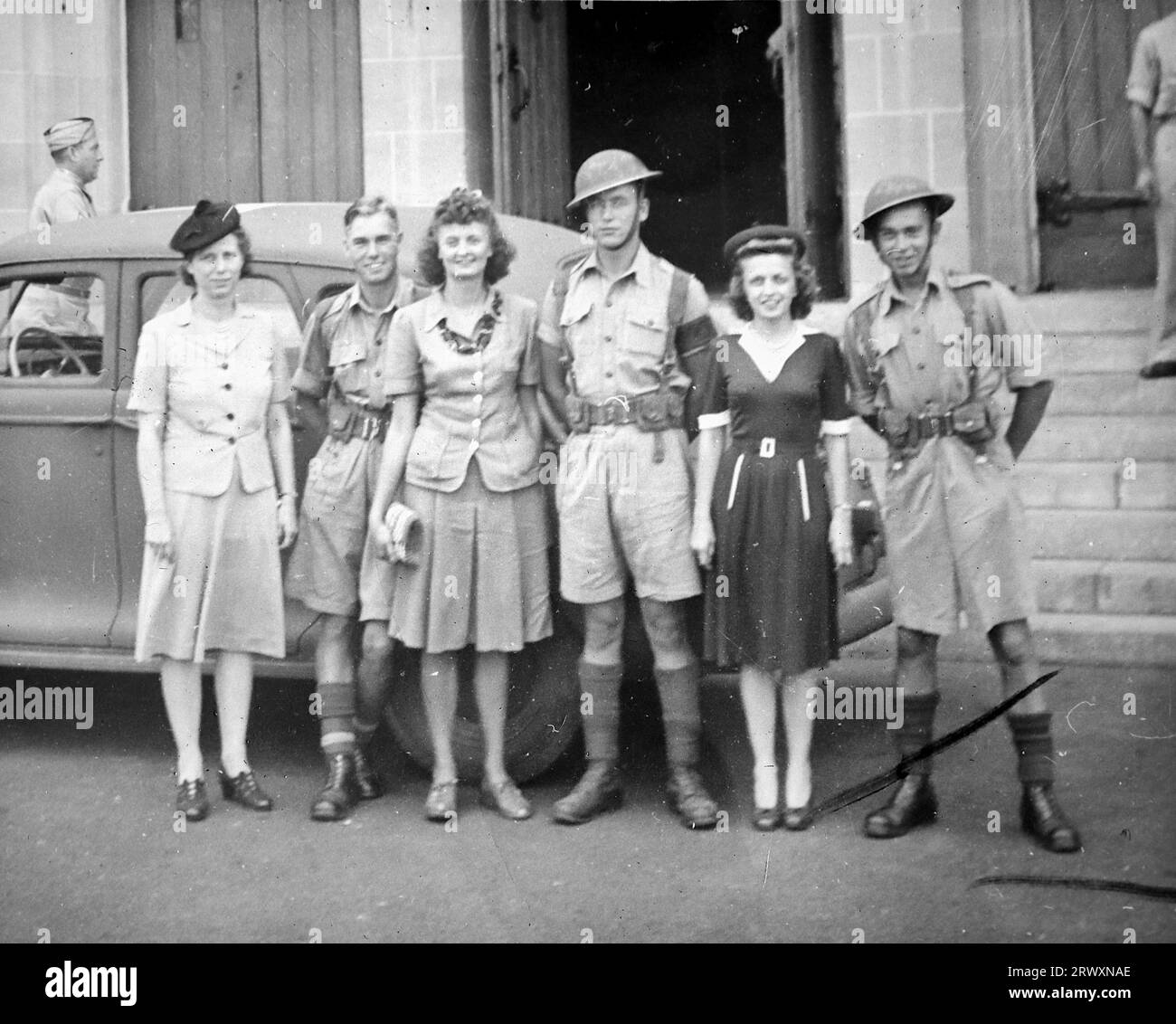 Eine Gruppe von Soldaten und Frauen, die neben einem Auto in Hollywood posieren. Seltenes Foto: Aus einer Sammlung eines unbekannten britischen Soldaten über die No. 1 Composite Demonstration, AA Battery, Tour durch die USA, vom 11. Juli 1943. Dies ist eines von mehr als hundert Bildern in der Sammlung, die im Durchschnitt etwa 4 x 3 Zoll groß waren. Stockfoto