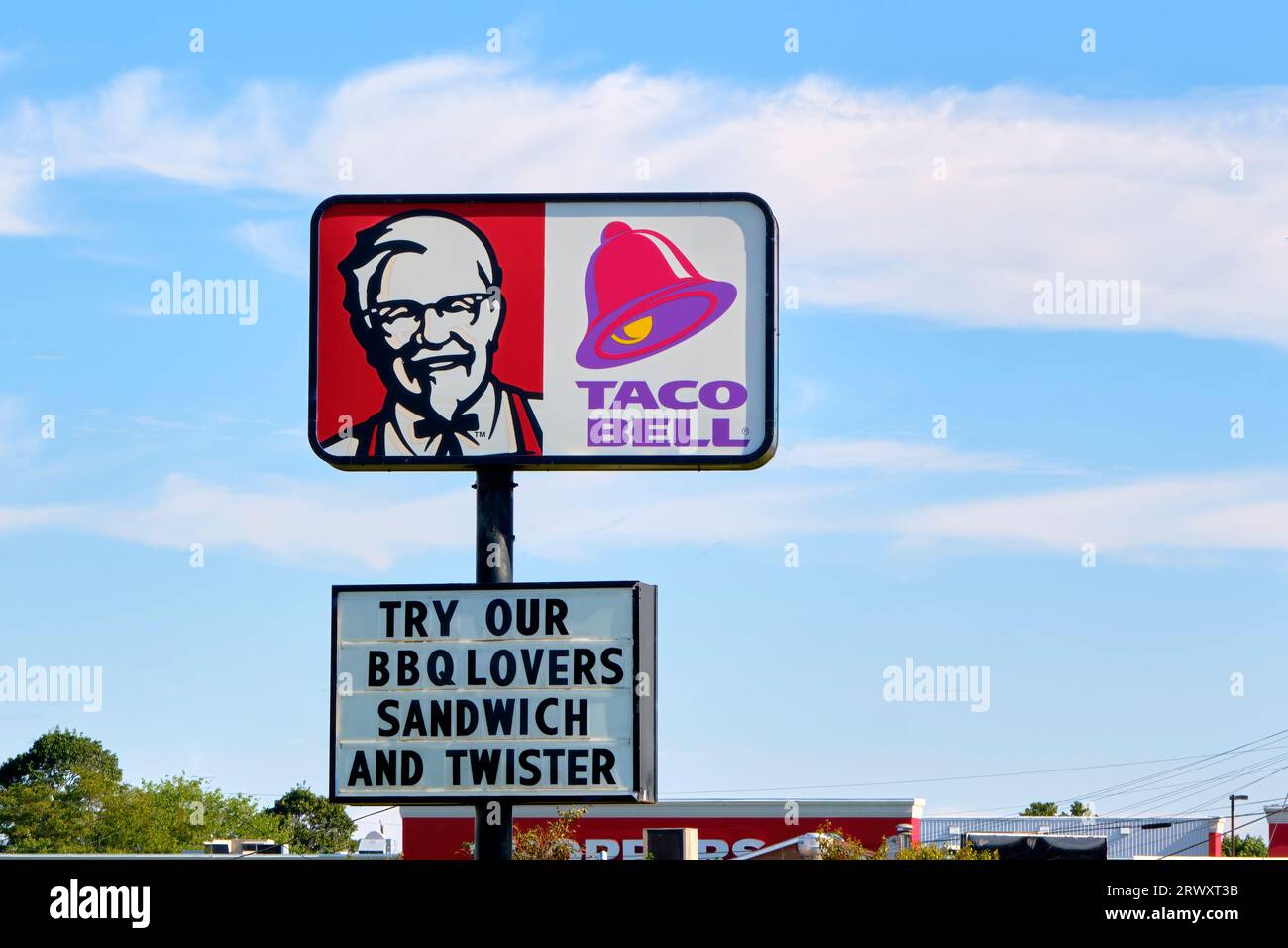 Das Schild „Kentucky Fried Chicken Taco Bell“ wurde vor einem blauen Himmel gerahmt und bietet viel Platz für Kopien. Stockfoto