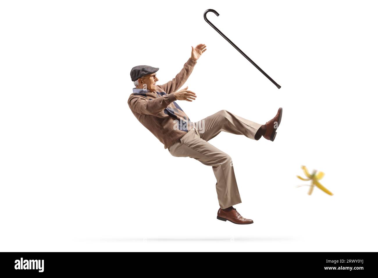 Älterer Mann mit einem Gehstock, der auf einer Bananenhaut auf weißem Hintergrund abrutscht Stockfoto