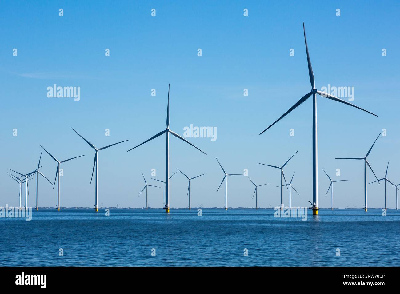 Windturbinen auf der Fryslan Windfarm am IJsselmeer (IJssel-See) in den Niederlanden. Windpark Fryslan am IJssel-See gebaut. Der Windpark umfasst 89 Turbinen mit einer Leistung von 4,3 Megawatt (MW). Jährlich produziert WFF 1.500.000 Megawattstunden. Der Windpark Fryslan ist der größte Windpark der Welt in einem Binnengewässer. Stockfoto