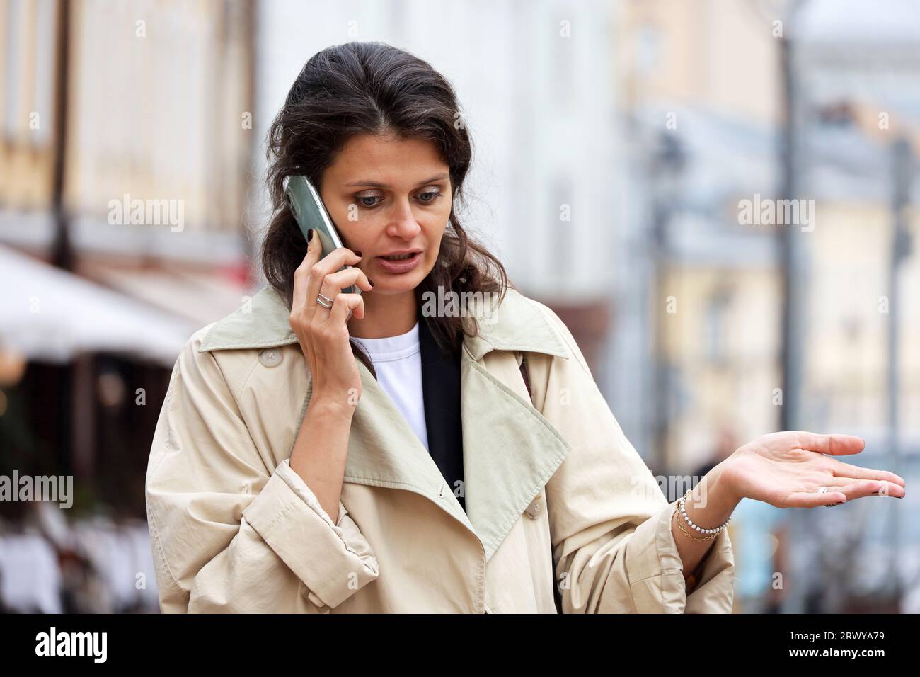 Frau, die emotional auf dem Handy auf der Straße spricht Stockfoto