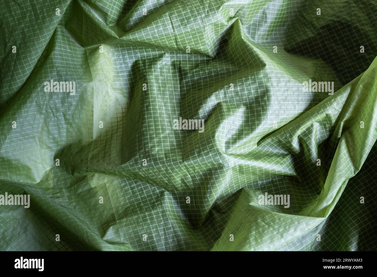 Nahaufnahme aus grünem kariertem Nylon-Zeltgewebe, Texturhintergrund Stockfoto