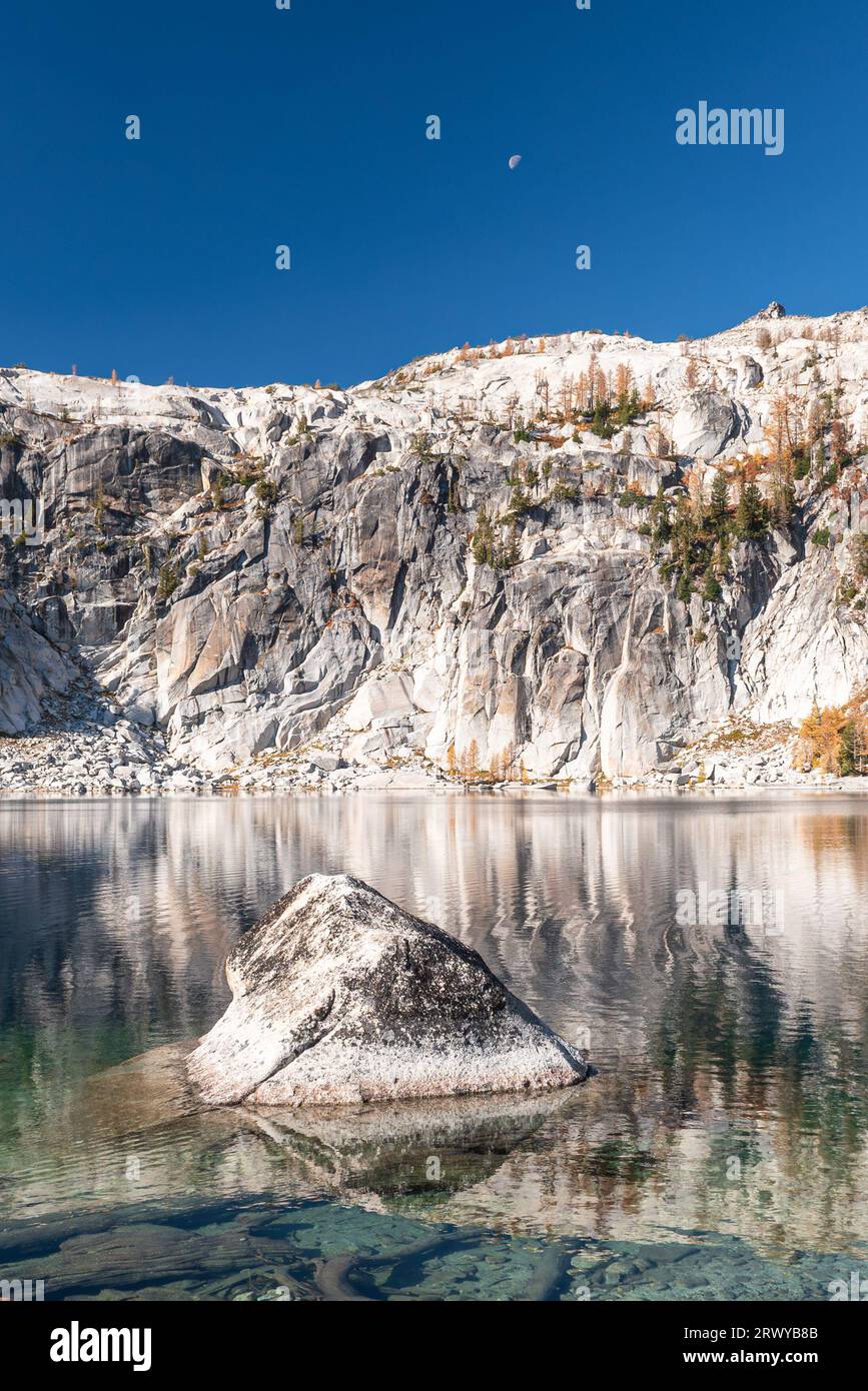 Der Mond erhebt sich über den Granitklippen des Prusik Peak und umgibt das klare, tiefblaue Wasser des Lake Viviane in der Enchantment Lakes Wilderness in Wash Stockfoto