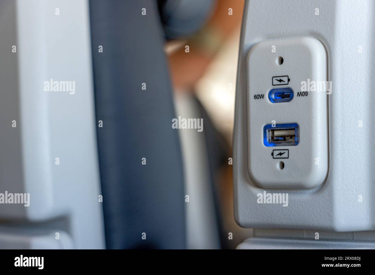 USB-Anschluss am Sitz des Flugzeugs zum Aufladen der elektronischen Geräte auf Reisen Stockfoto