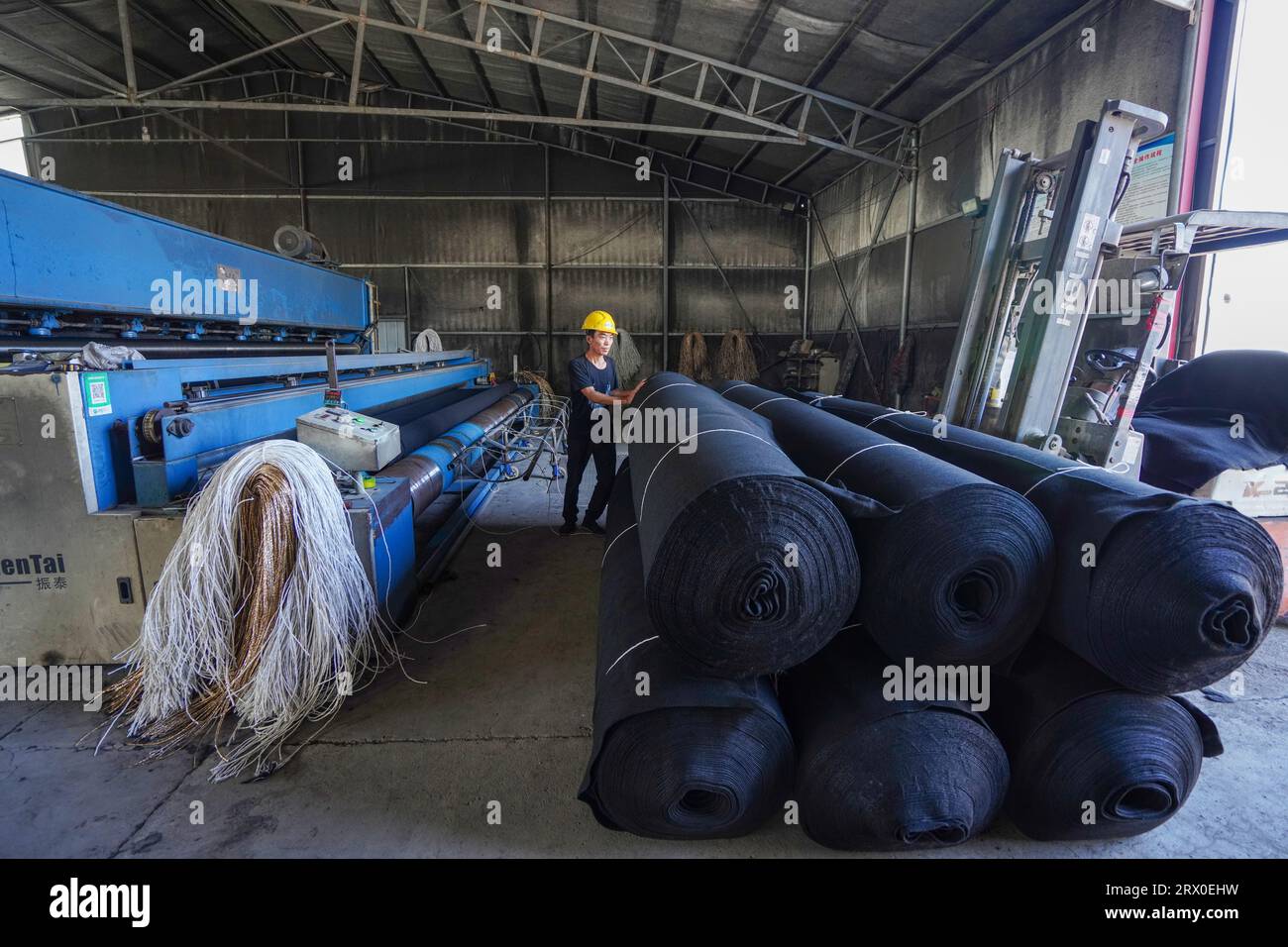 Luannan County, China - 24. August 2022: Arbeiter binden Vliesstoffe in einer Fabrik. Stockfoto