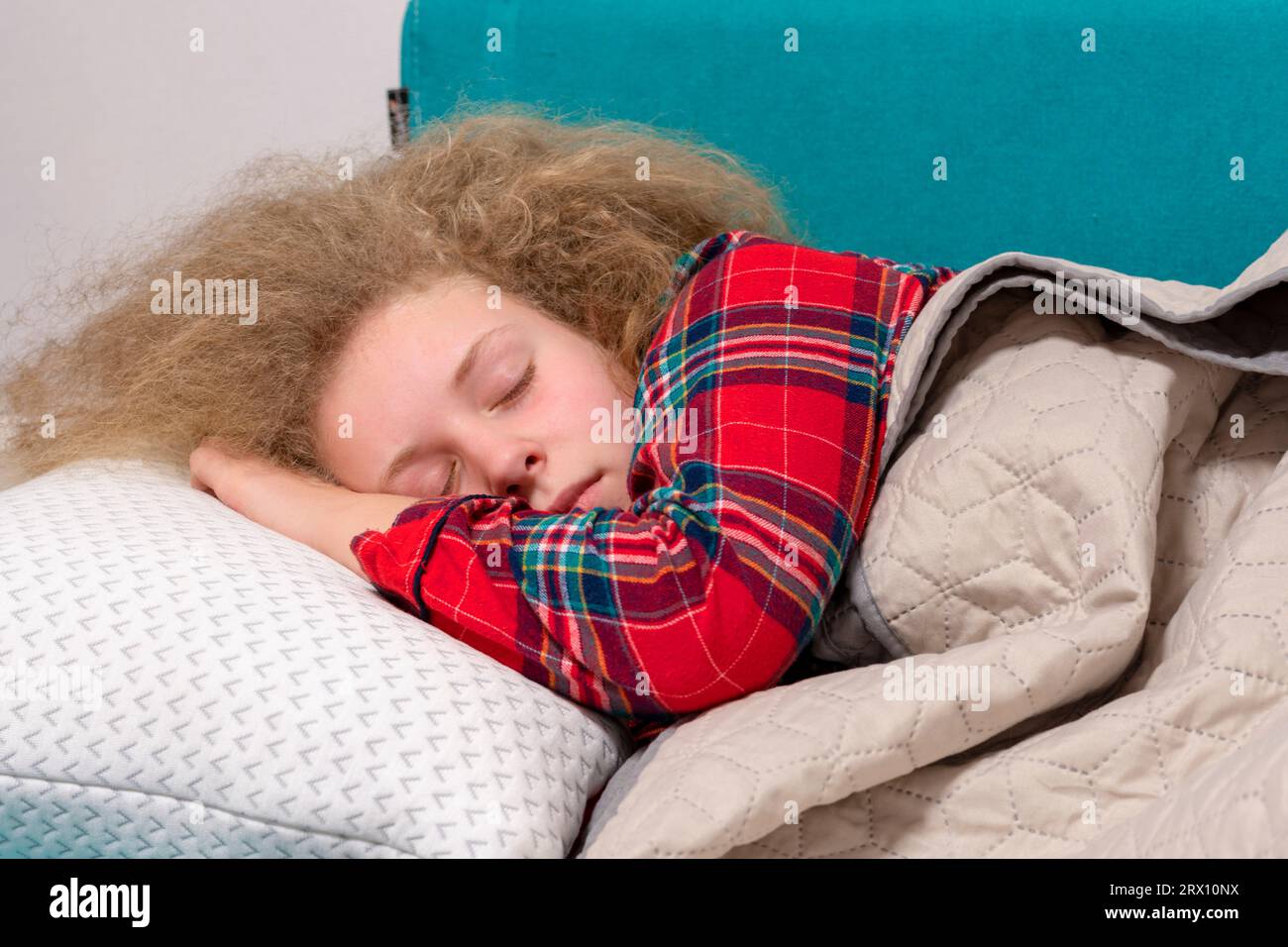 Mädchen schläft im Bett. Schönes Mädchen schläft im Schlafzimmer. Konzept eines guten, gesunden Schlafs. Junge Frau mit einer Decke bedeckt, die im Bett liegt Stockfoto