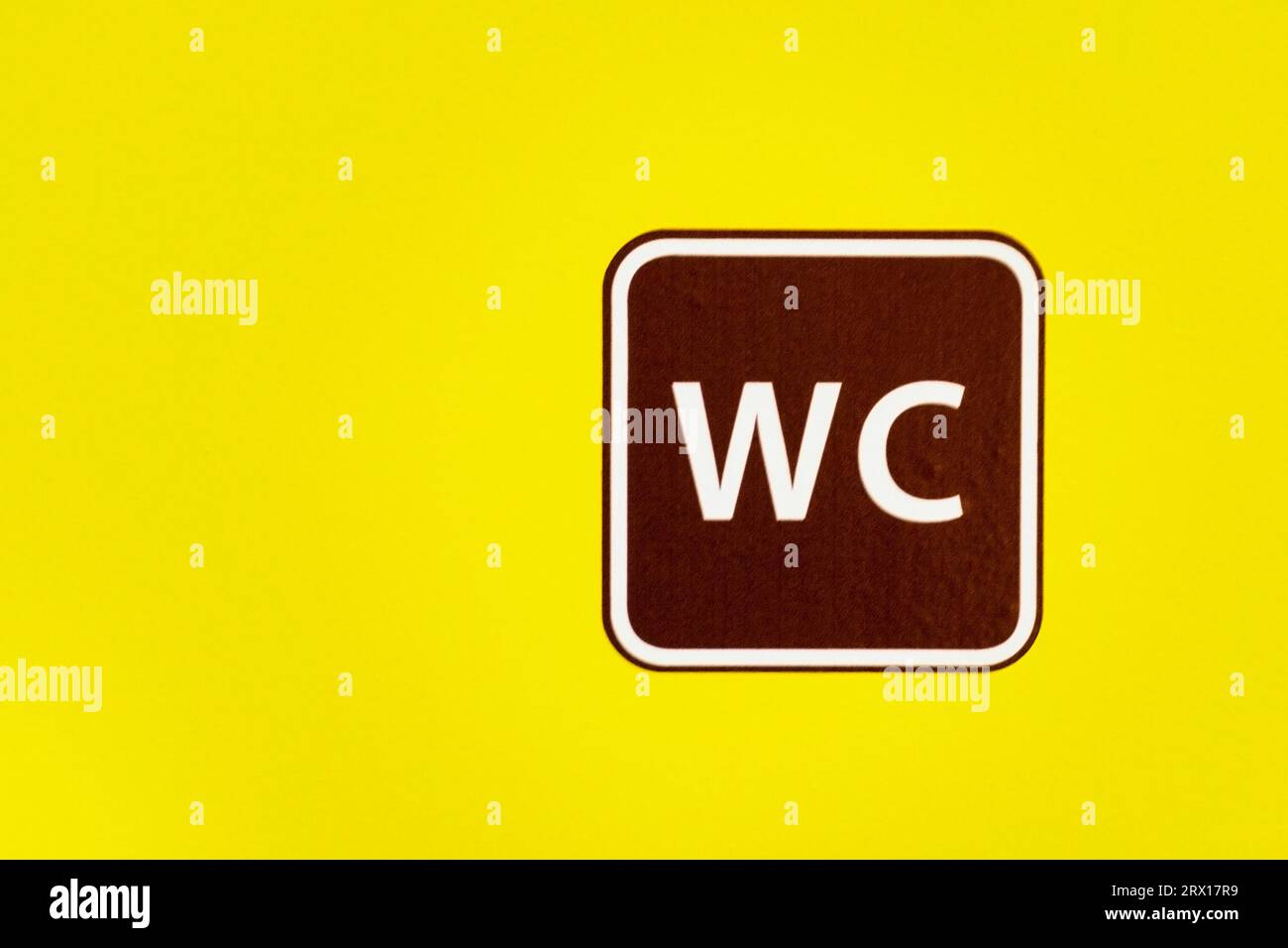 Das Zeichen eine Toilette auf gelbem Hintergrund. Copyspace. Abkürzung WC. Symbol des Badezimmers Stockfoto