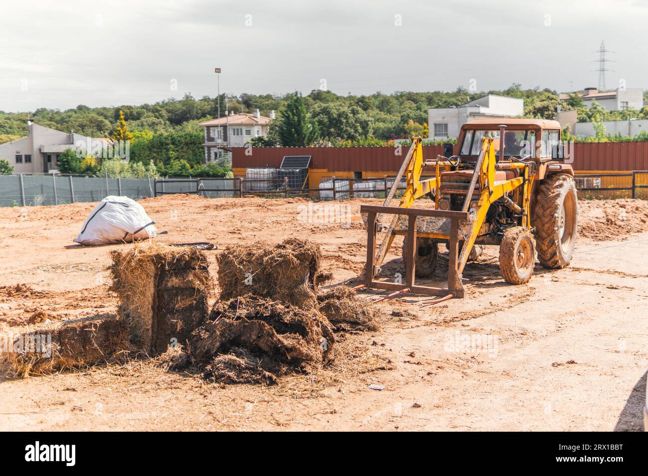 Mann bewegt Stroh mit einem alten Traktor Stockfoto