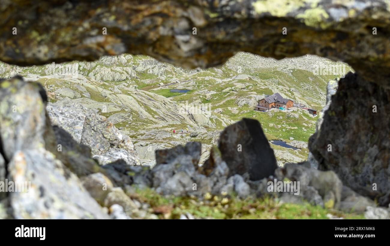 Blick durch ein Felsenfenster auf die Magdeburger Huette in den Stubaier Alpen, Südtirol, Italien Stockfoto