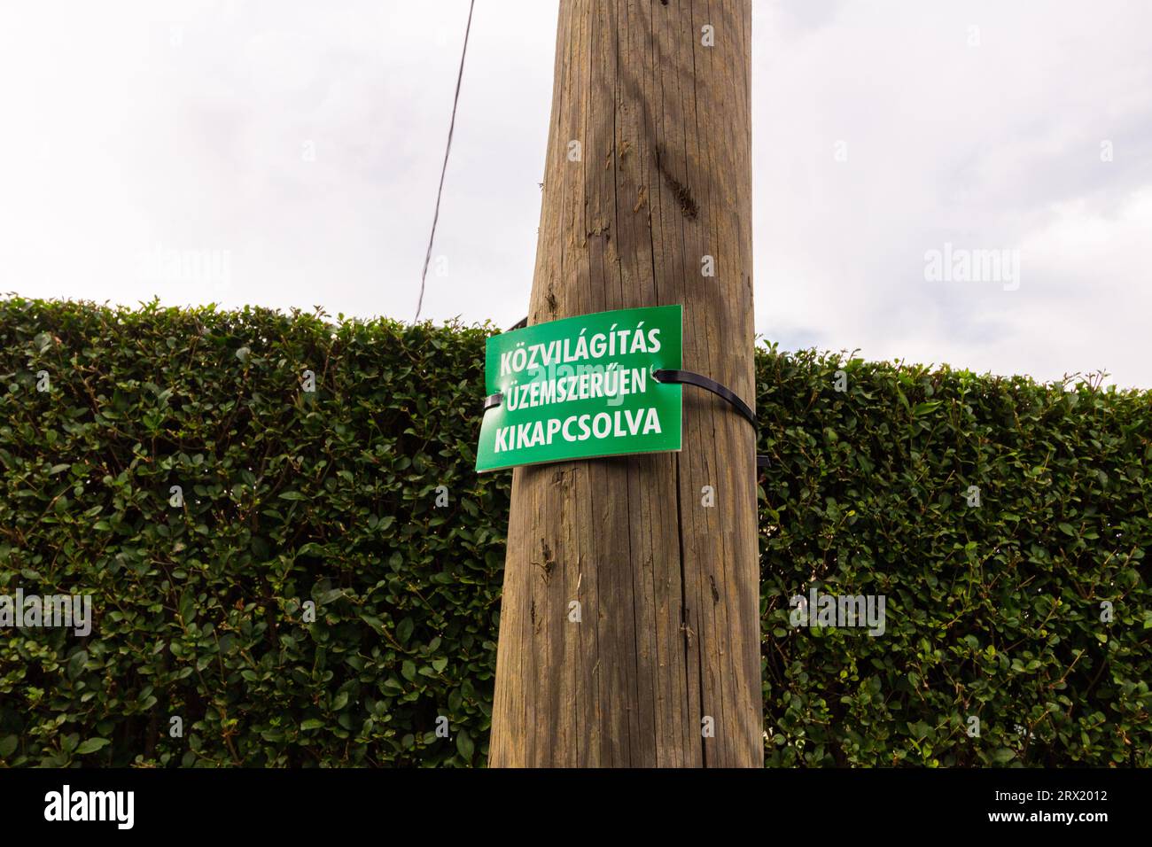 Schild „Kozvilagitas uzemszeruen kikapcsolva“ (Straßenlaterne aus Energiespargründen ausgeschaltet), Sopron, Ungarn Stockfoto