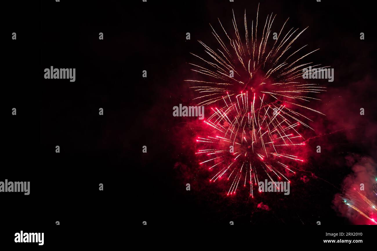 Buntes Feuerwerk auf dem schwarzen Himmel Hintergrund mit freiem Platz für Text. Feier- und Jubiläumskonzept Stockfoto