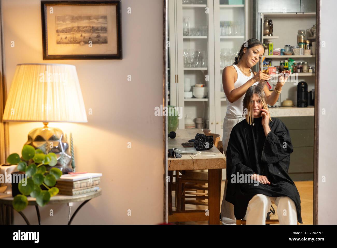 Eine Frau, die einen Friseur besucht, hat einen Friseurtermin in ihrer Wohnung, London, England, Großbritannien Stockfoto