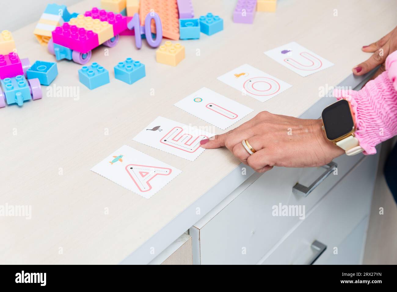 Hand eines Psychopedagogen mit Buchstaben des Alphabets. Schulungshilfe. Psychische Versorgung. Stockfoto