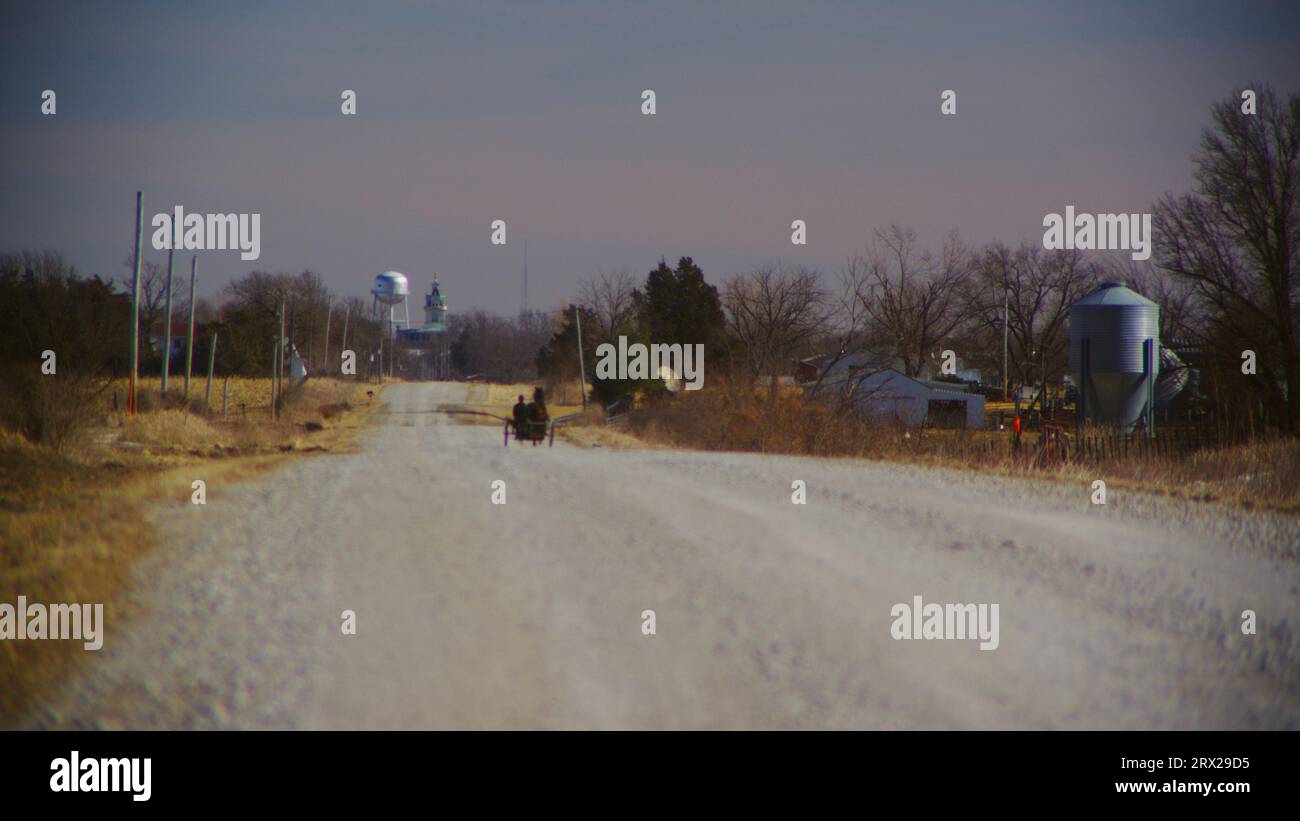 Ein Amish-Mann in einem Pferdewagen fährt frei über eine Schotterstraße in Richtung Bloomfield im Davis County, Iowa. Stockfoto