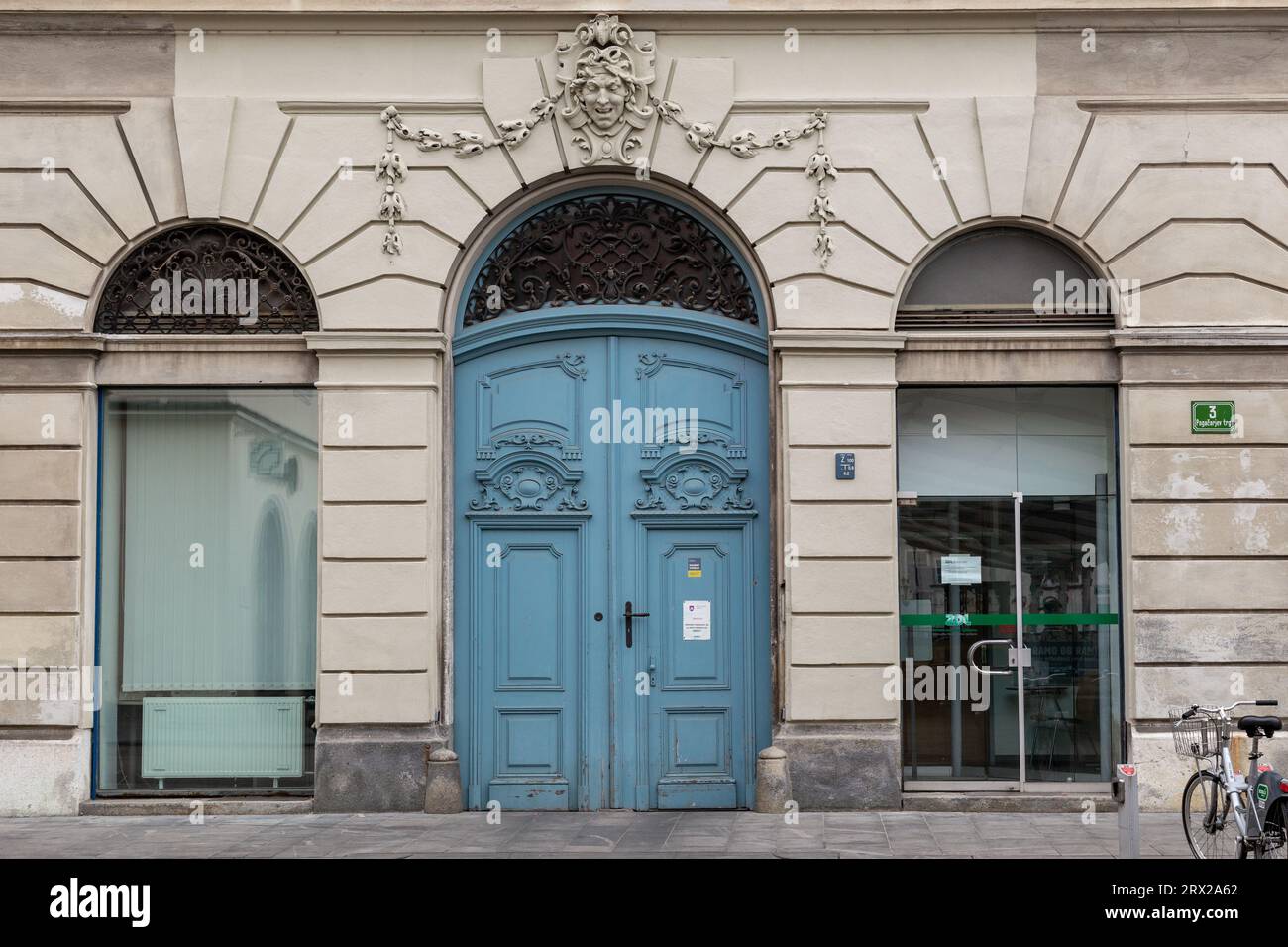 LJUBLJANA, SLOWENIEN - 7. MÄRZ 2023: Dies ist ein Fragment der Fassade eines alten Barockhauses mit geschnitzten Holztüren und dekorativer Dekoration darüber Stockfoto